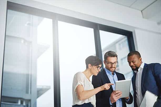Shot of a team of colleagues using a digital tablet together at work Shot of a team of colleagues using a digital tablet together at work